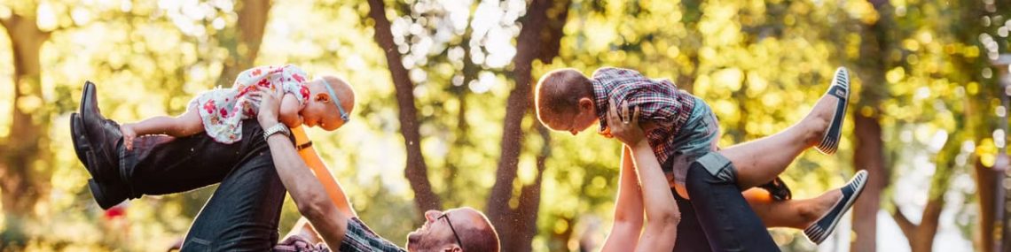 A joyful family enjoying playtime in a sunny park, capturing moments of laughter and happiness.